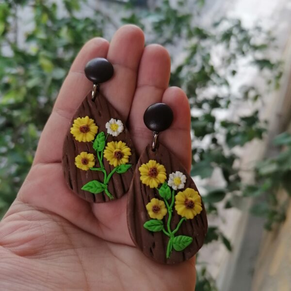 Αναδείξτε την εμφάνισή σας με αυτά τα μοναδικά σκουλαρίκια από πολυμερικό πηλό, διακοσμημένα με φωτεινά λουλούδια και υφή ξύλου.