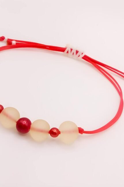 Γυναικείο βραχιόλι για τον Μάρτη που όμως φοριέται όλο τον χρόνο! Φτιαγμένο από διπλό κόκκινο νήμα 1mm, όπου έχουν συνδυαστεί λευκές frosted χάντρες (8mm) με χάντρες stardust (4mm) σε κόκκινο του κρασιού. Με αυξομειούμενο κλείσιμο ώστε να ταιριάζει σε κάθε καρπό.