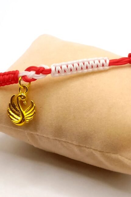 Ξεχωριστό, γυναικείο μαρτάκι που μπορεί να φορεθεί επίσης και ως ματάκι ή ένα ιδιαίτερο μακραμέ βραχιόλι καθ' όλη την διάρκεια του χρόνου. Πλεγμένο από δύο νήματα του 1mm, σε κόκκινο με λευκό που καταλήγουν σε σχέδιο "άπειρο" στο κέντρο του βραχιολιού. Σ' αυτό το σημείο ακριβώς έχει προστεθεί κρεμαστό στοιχείο "κύκνος" σε χρυσό χρώμα. Το σχέδιο ολοκληρώνεται με ματόχαντρο, περασμένο στο πλάι του βραχιολιού. Με αυξομειούμενο κλείσιμο ώστε να ταιριάζει σε κάθε καρπό.