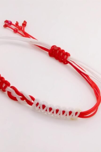 Ένας ξεχωριστός Μάρτης για όλους, που κάλλιστα μπορείτε να τον φορέσετε και ως μακραμέ βραχιόλι όλο το χρόνο. Πλεγμένο από δύο νήματα του 1mm, σε κόκκινο με λευκό που καταλήγουν σε σχέδιο "άπειρο" στο κέντρο του βραχιολιού. Με αυξομειούμενο κλείσιμο ώστε να ταιριάζει σε κάθε καρπό.