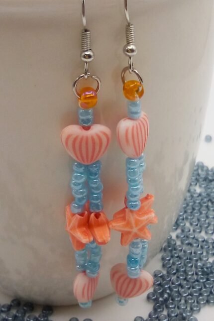 Κρεμαστα καλοκαιρινά σκουλαρίκια με ιριδίζουσες γαλάζιες γυάλινες χάντρες και πορτοκαλί ακρυλικά αστεράκια και καρδιές.