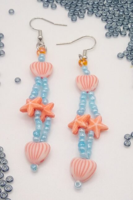 Κρεμαστα καλοκαιρινά σκουλαρίκια με ιριδίζουσες γαλάζιες γυάλινες χάντρες και πορτοκαλί ακρυλικά αστεράκια και καρδιές.
