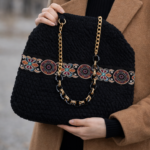 Γυναικεία χειροποίητη πλεκτή τσάντα ώμου και χειρός από βελουτέ νήμα σε μαύρο χρώμα και διακοσμητική τρέσα.