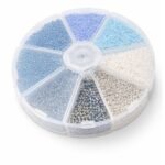 Round plastic wheel organizer with 7 sections of blue, white and clear seed beads.